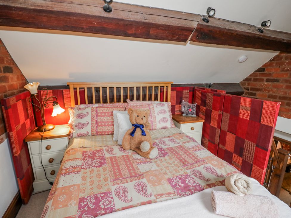A bedroom with a bed and teddy bear at The Haybarn in Lichfield