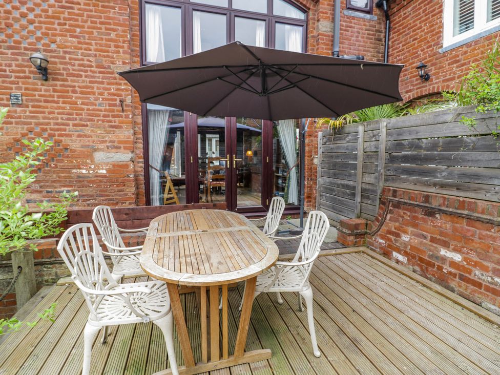 An outdoor seating area with a table and chairs at The Haybarn in Lichfield