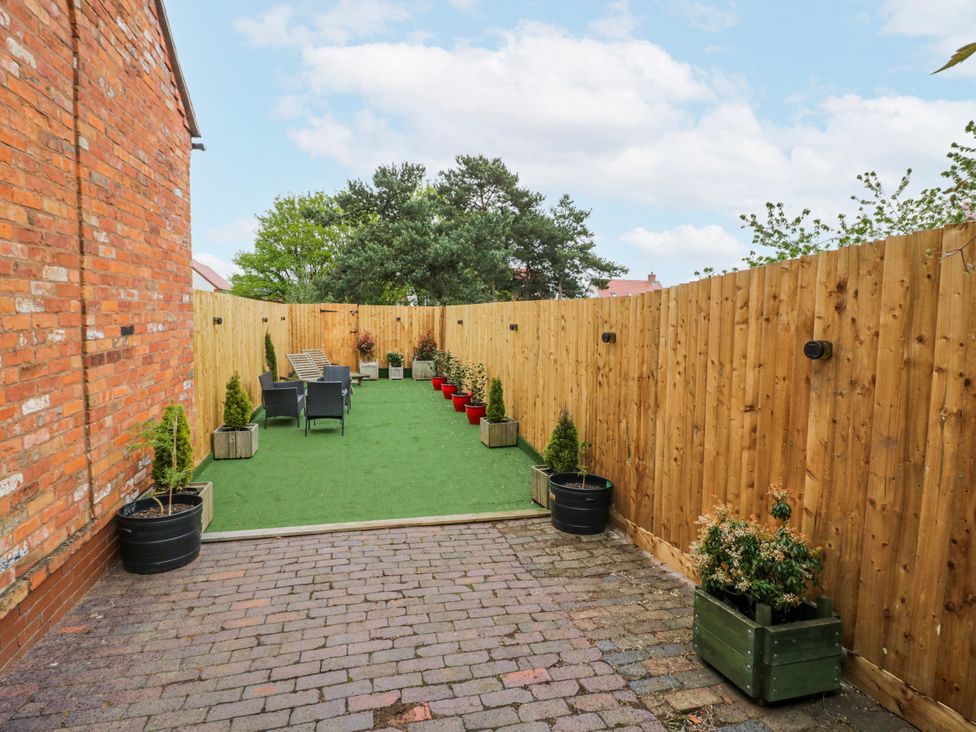 A garden area with artificial grass and seating at The Haybarn in Lichfield