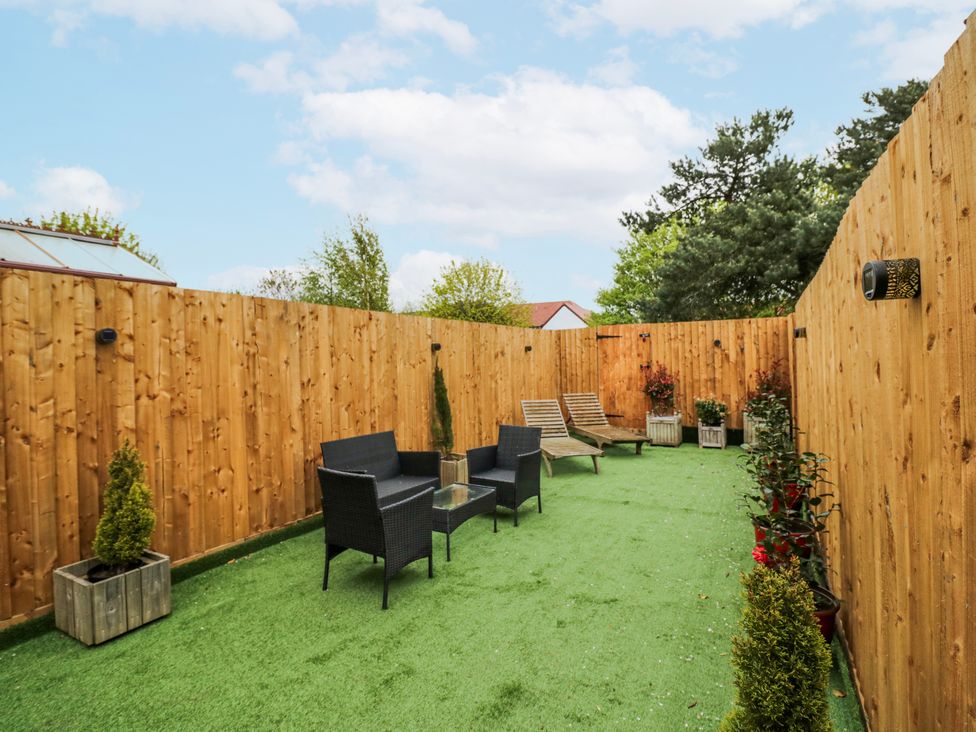 A garden with seating and planters at The Haybarn in Lichfield