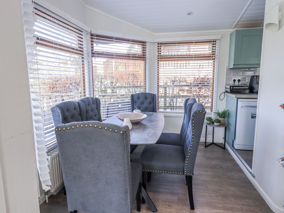 A dining room with a table and chairs at JacMar Lodge 14 Applethwaite Limefitt Park near Windermere