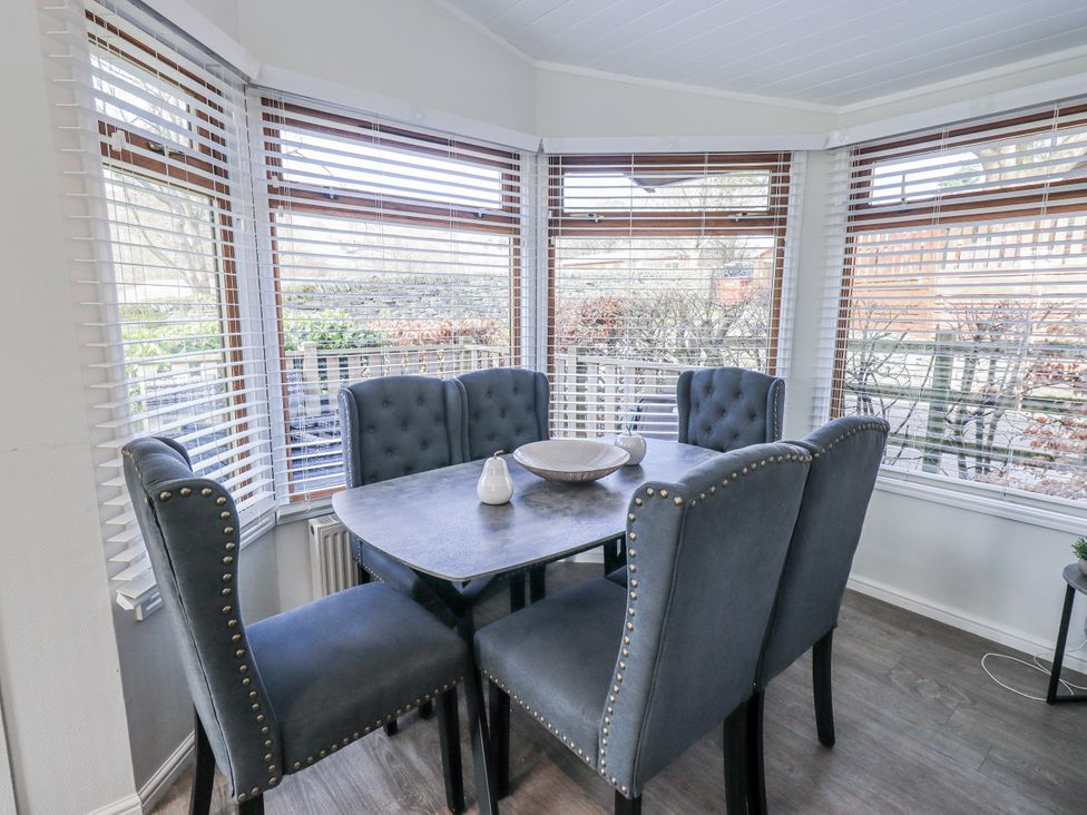 A dining room with a table and chairs at JacMar Lodge 14 Applethwaite Limefitt Park near Windermere