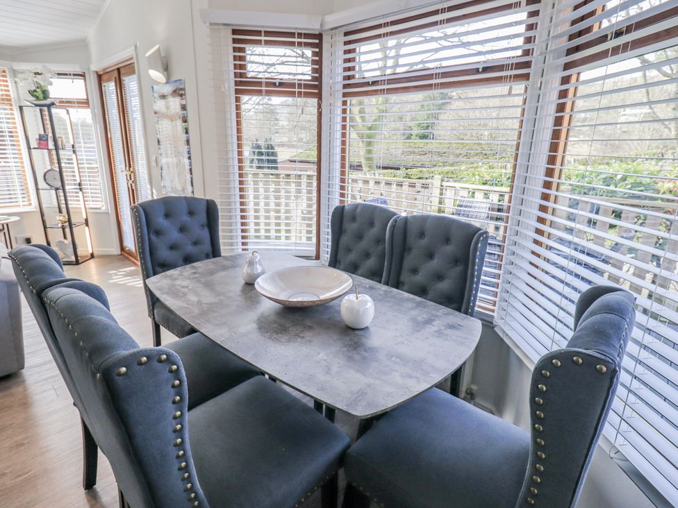 A dining room with a table and chairs at JacMar Lodge, 14 Applethwaite, Limefitt Park near Windermere