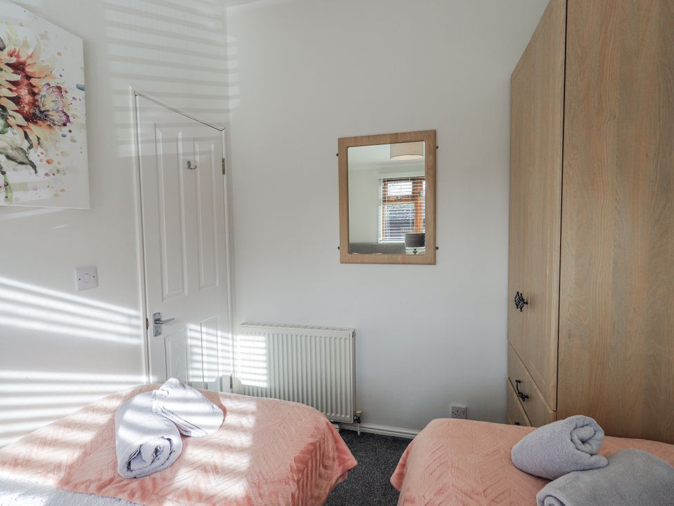 A bedroom with two beds and a mirror at JacMar Lodge, 14 Applethwaite, Limefitt Park near Windermere