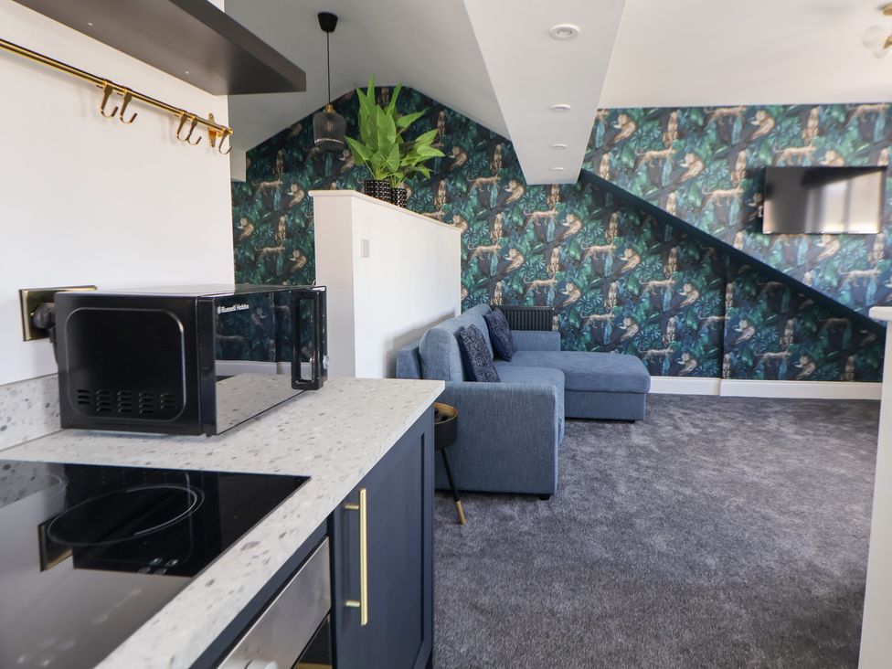 A living room with a sofa and television at The Alhambra in Southport
