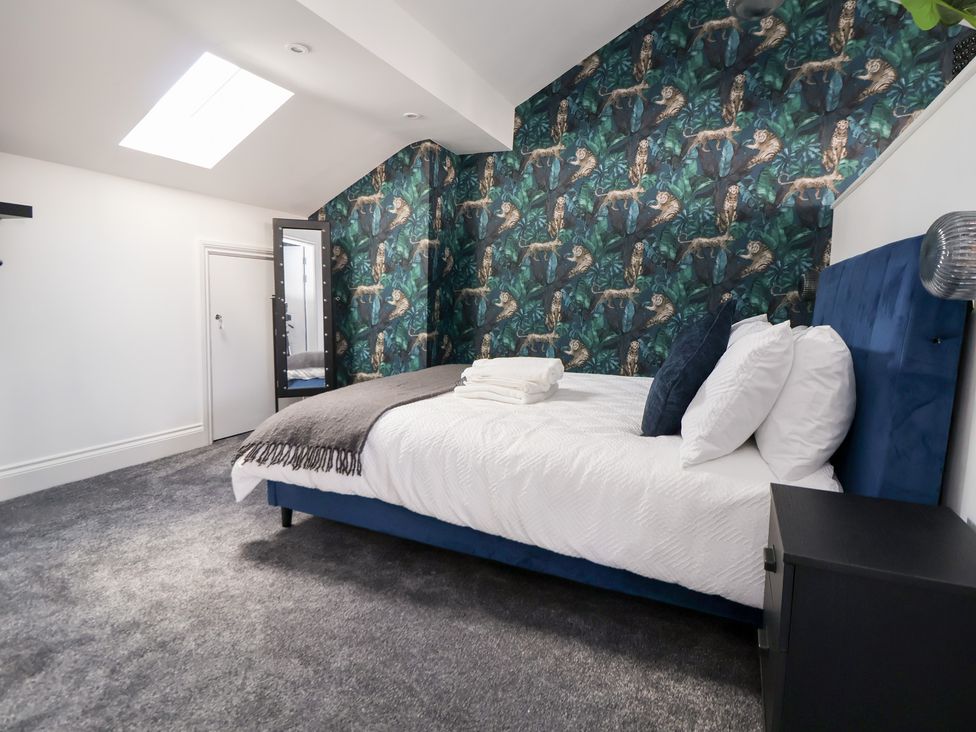 A bedroom with a bed and bedside table at The Alhambra in Southport
