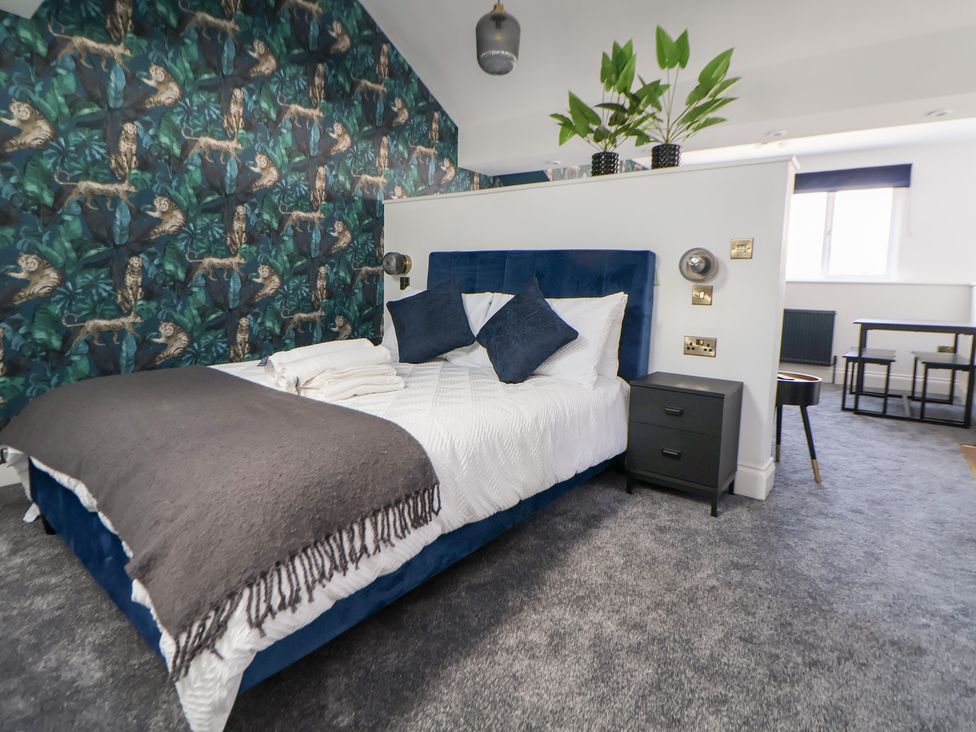 A bedroom with a bed and bedside table at The Alhambra in Southport