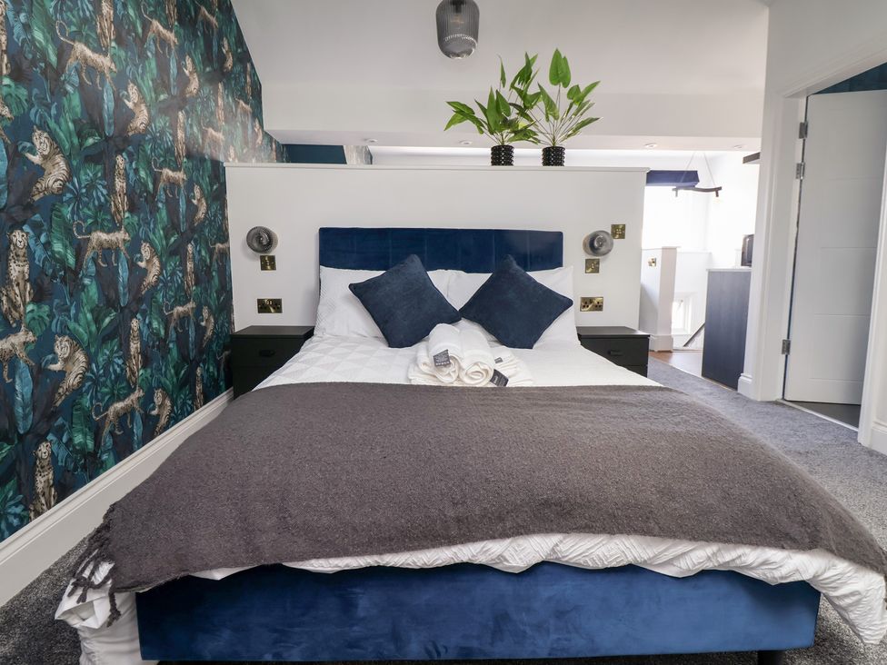A bedroom with a bed and plants at The Alhambra in Southport