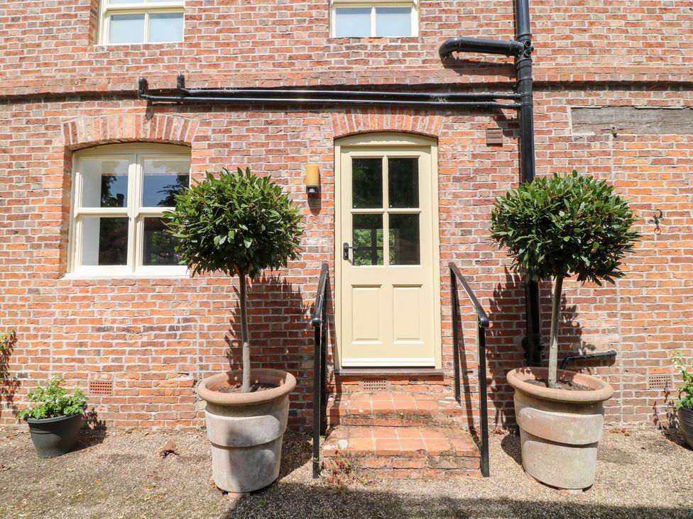 An entrance with potted plants and a front door at The Old Barn in Caenby near Market Rasen