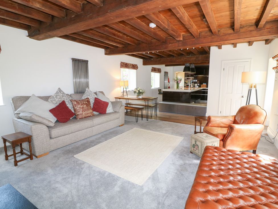 A living room with a sofa and dining table at The Old Barn in Caenby near Market Rasen