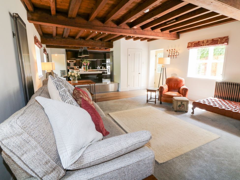 A living room with a sofa and an armchair at The Old Barn in Caenby near Market Rasen