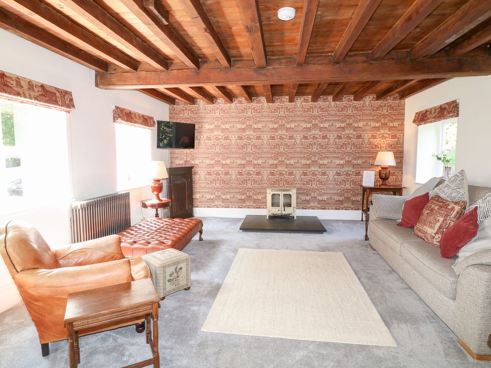 A living room with a sofa and armchair at The Old Barn in Caenby near Market Rasen