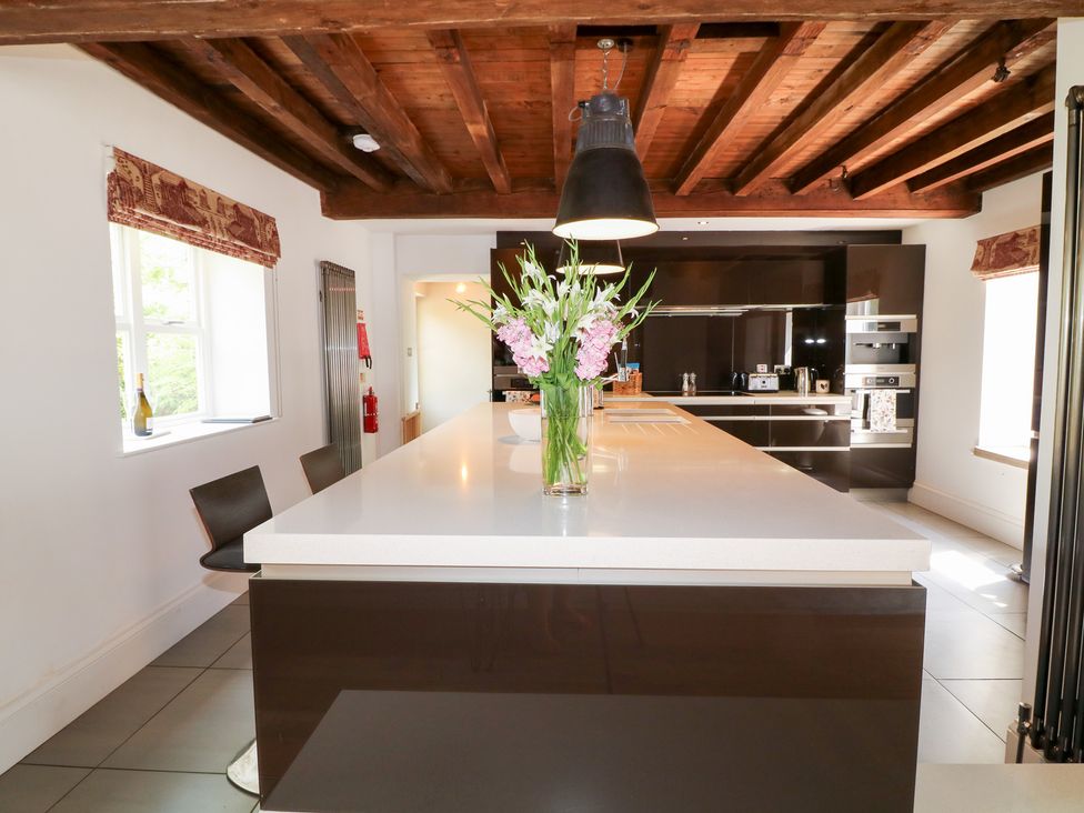 A kitchen with an island and flowers at The Old Barn in Caenby near Market Rasen