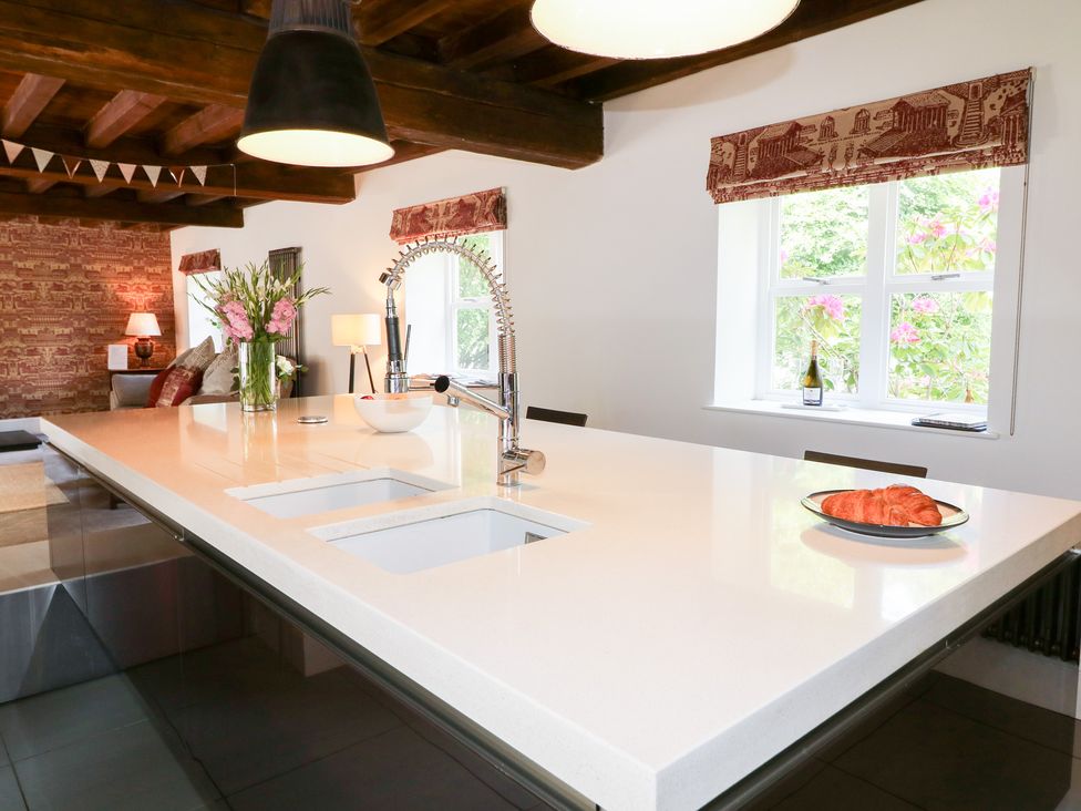A kitchen with a large island and sink at The Old Barn in Caenby near Market Rasen