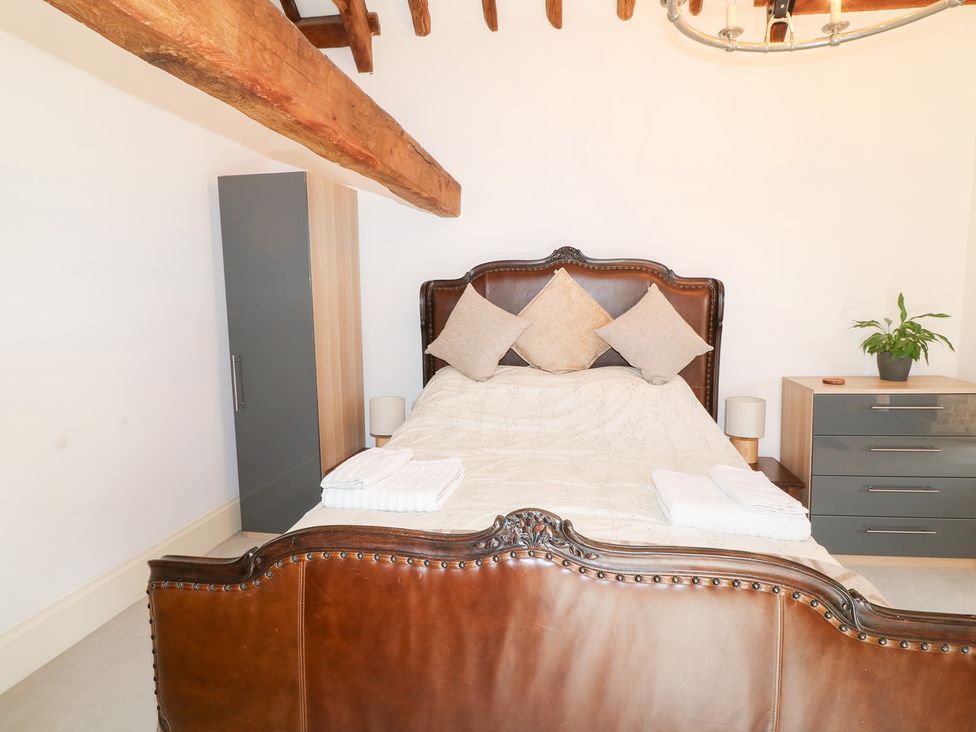 A bedroom with a bed and nightstand at The Old Barn in Caenby near Market Rasen
