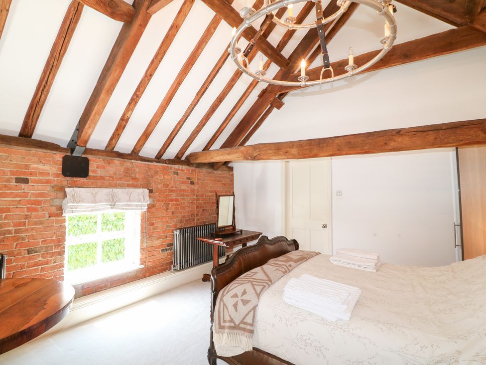 A bedroom with a bed and a table at The Old Barn in Caenby near Market Rasen
