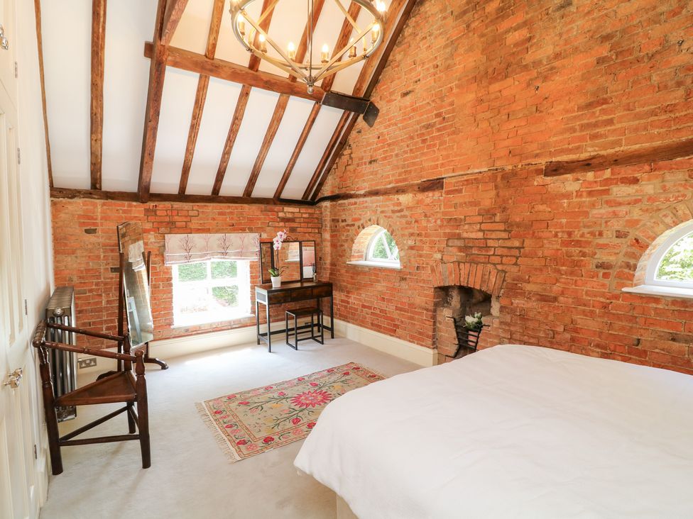 A bedroom with a bed and furniture at The Old Barn in Caenby near Market Rasen