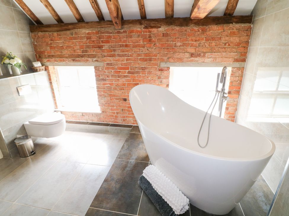 A bathroom with a bathtub and a toilet at The Old Barn in Caenby near Market Rasen