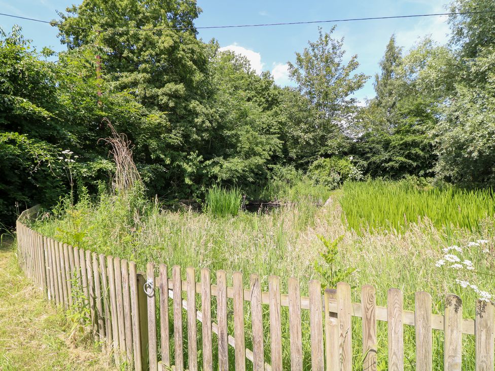 An outdoor area with a wooden fence and vegetation at The Old Barn in Caenby near Market Rasen