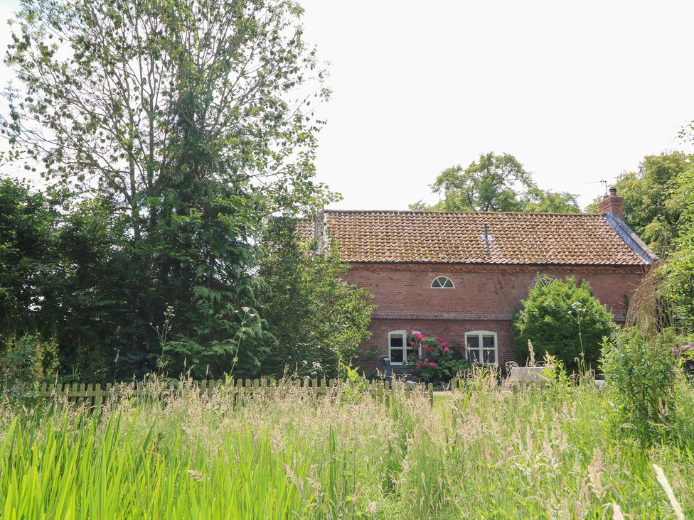 A house with trees and grass in the outdoor area at The Old Barn in Caenby near Market Rasen