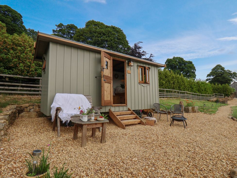 An outdoor area with a tiny house and table with chairs at Lodge Farm in Whitby