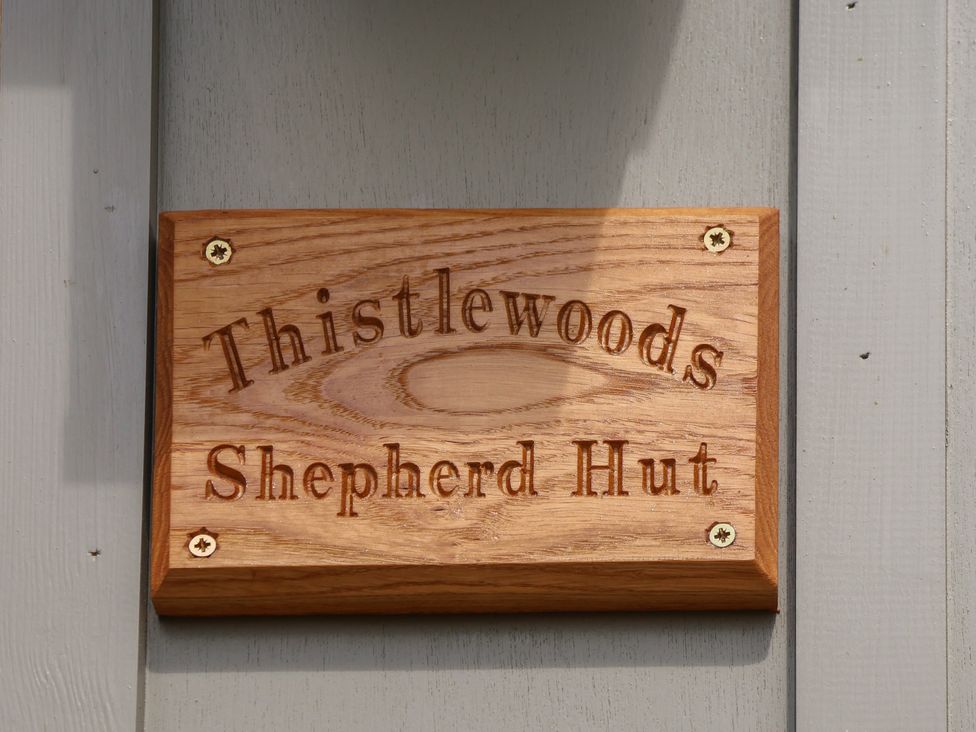 A wooden sign for Thistlewoods Shepherd Hut at Lodge Farm Whitby