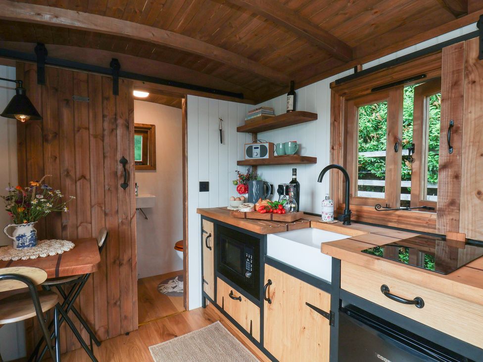A kitchen with wooden shelves and a table at Lodge Farm in Whitby