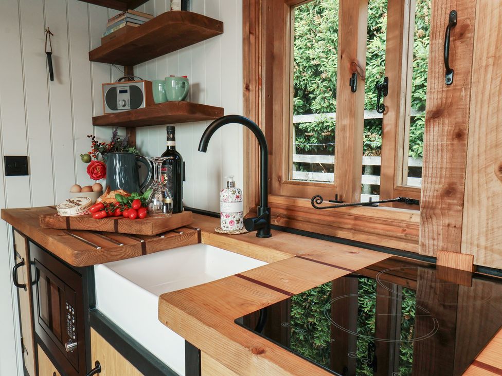 A kitchen with a sink, stove, and shelves at Lodge Farm in Whitby