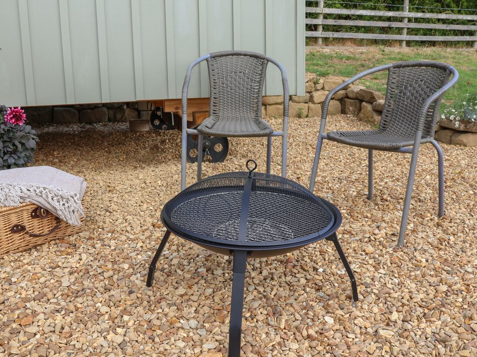 An outdoor seating area with chairs and a fire pit at Lodge Farm in Whitby