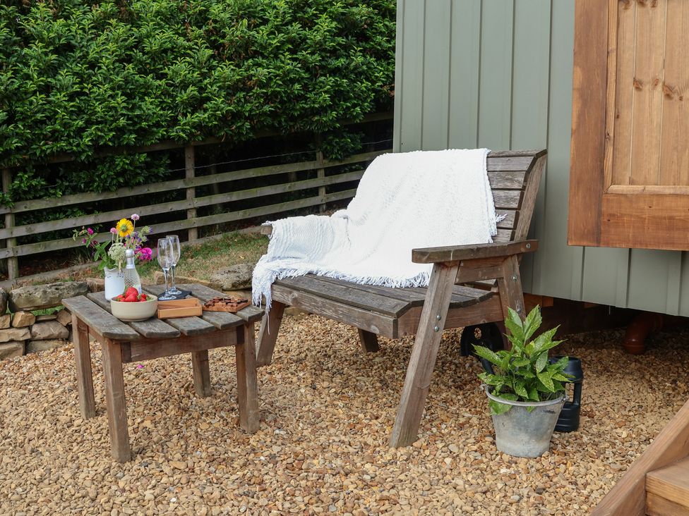 An outdoor seating area with a bench and table at Lodge Farm in Whitby