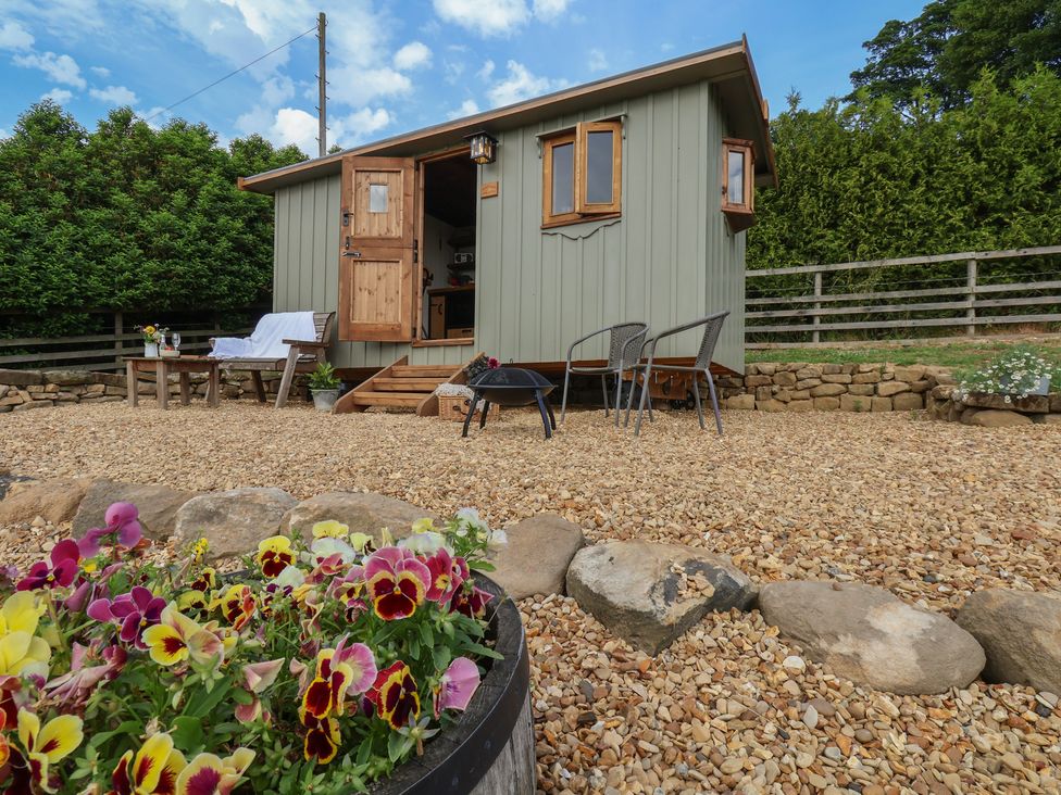 A hut with chairs and a table in front at Lodge Farm in Whitby