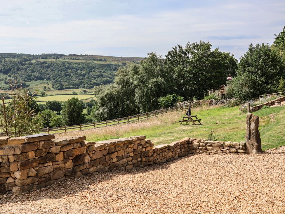 An outdoor area with a stone wall and a picnic table at Lodge Farm in Whitby
