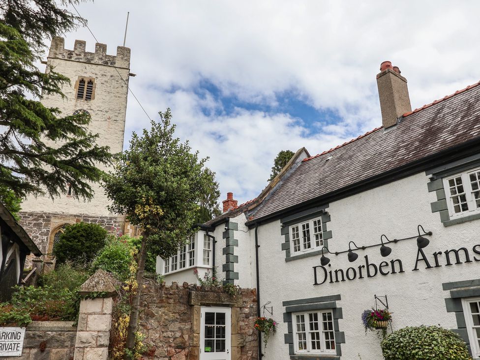 An exterior view of the Dinorben Arms building with a tower at The Studio Cottage in Denbigh