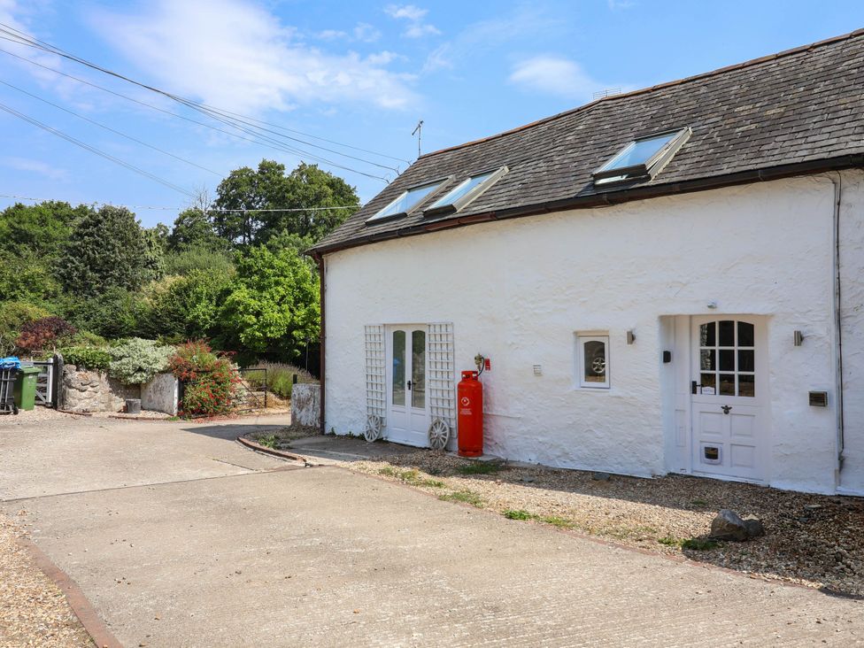 An outdoor area with a house and a gravel path at The Studio Cottage near Denbigh