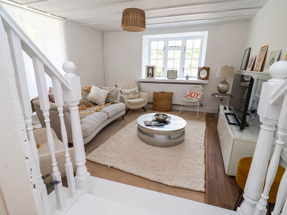 A living room with a sofa, table and television at The Studio Cottage near Denbigh