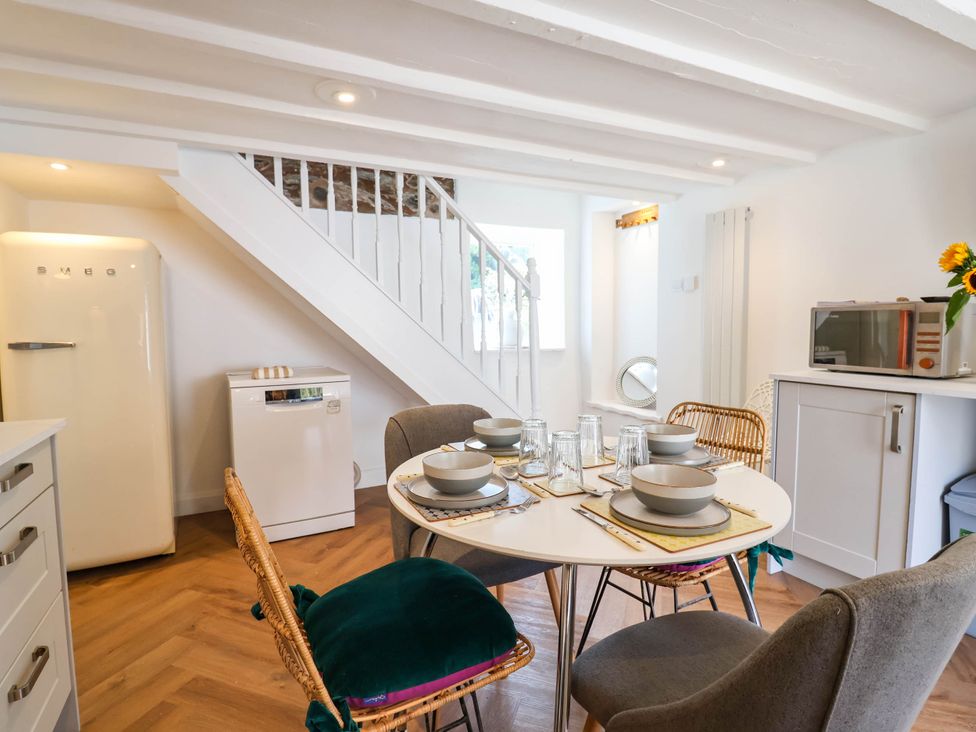 A kitchen with a dining table set in The Studio Cottage near Denbigh