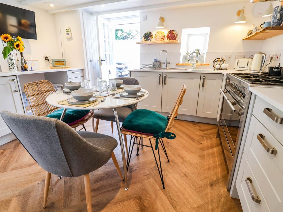 A kitchen with a dining table and chairs at The Studio Cottage near Denbigh
