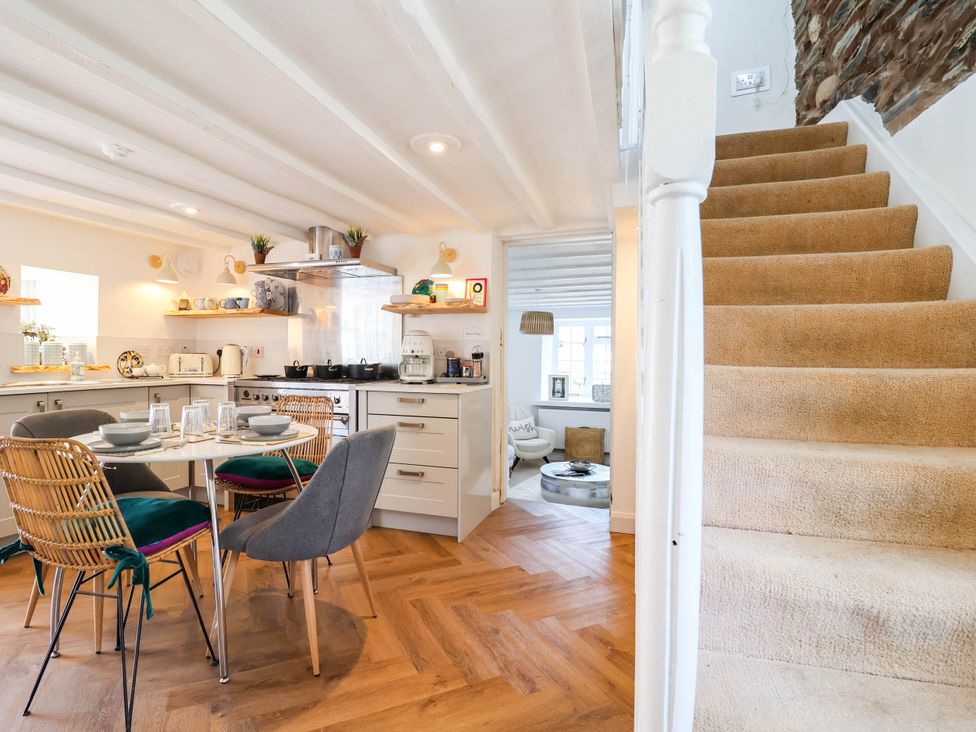 A kitchen with dining area and stairs at The Studio Cottage near Denbigh