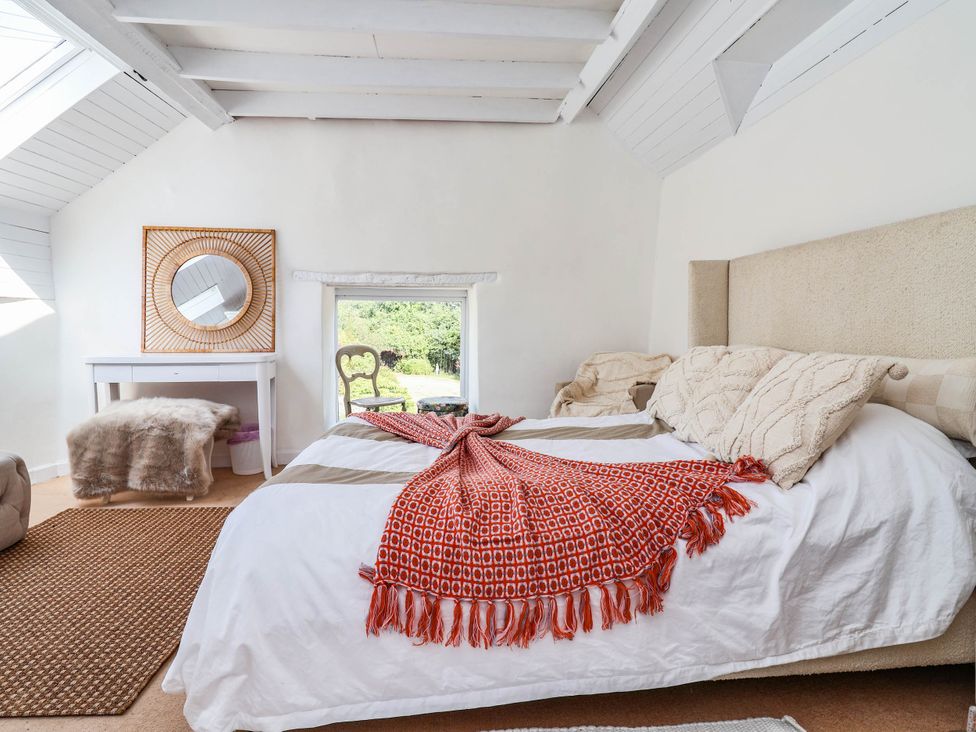 A bedroom with a bed and desk at The Studio Cottage near Denbigh