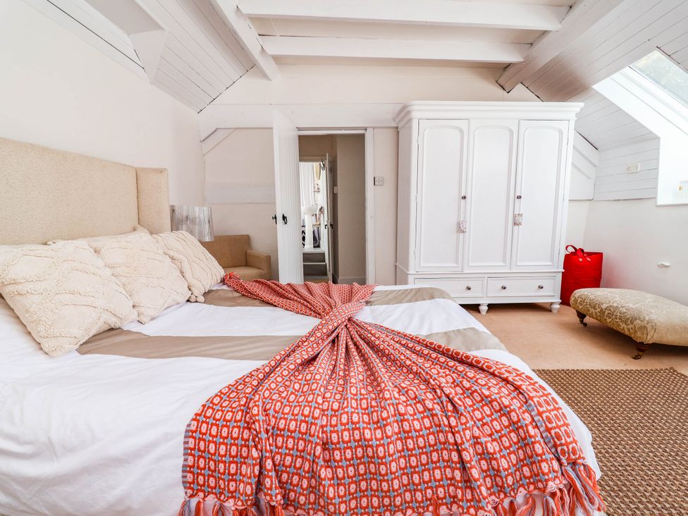 A bedroom with a bed and wardrobe at The Studio Cottage near Denbigh