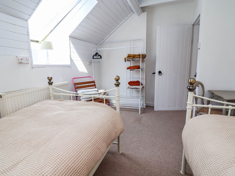 A bedroom with two beds and a coat rack at The Studio Cottage near Denbigh