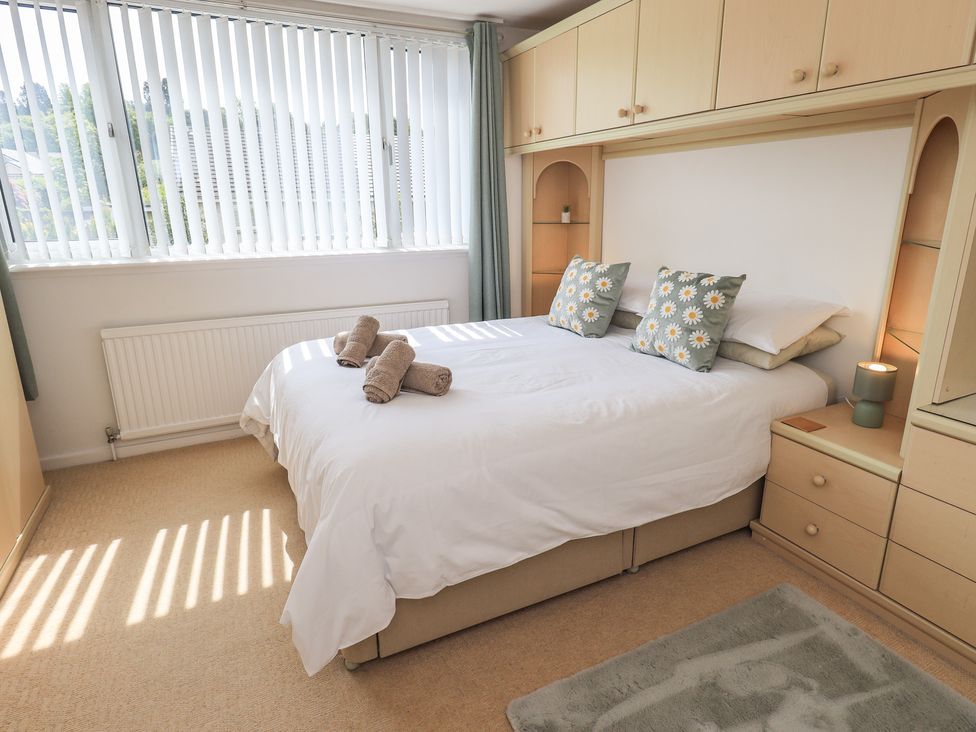 A bedroom with a bed and cushions at Oaklea in Keswick