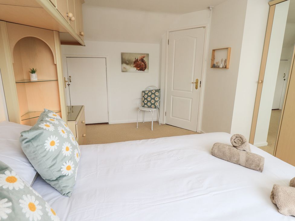 A bedroom with a bed and a chair at Oaklea in Keswick