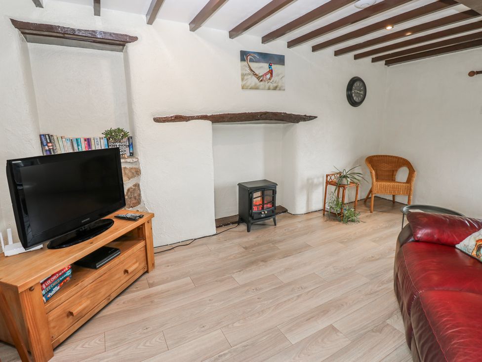 A living room with a television and a fireplace at The Granary in Ellingstring near Masham