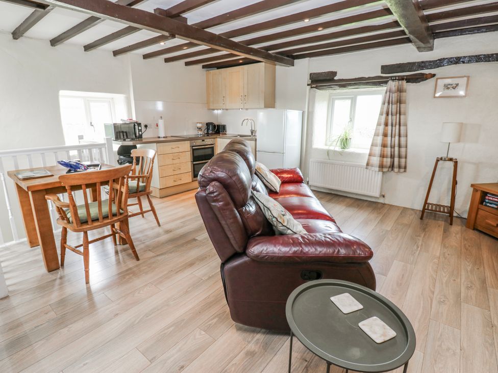 A living room with a sofa and dining table at The Granary in Ellingstring near Masham