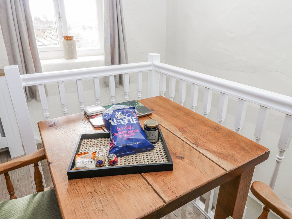 A dining area with a wooden table and snacks on a tray at The Granary in Ellingstring near Masham