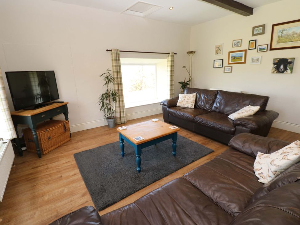 A living room with a television and sofas at The Hayloft in Ellingstring near Masham