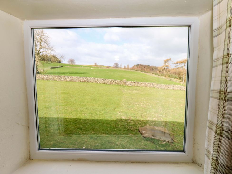 A view from a window showing a grassy landscape at The Hayloft Ellingstring near Masham