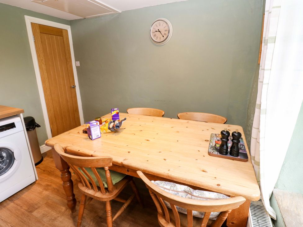 A kitchen with a dining table and chairs at The Hayloft in Ellingstring near Masham