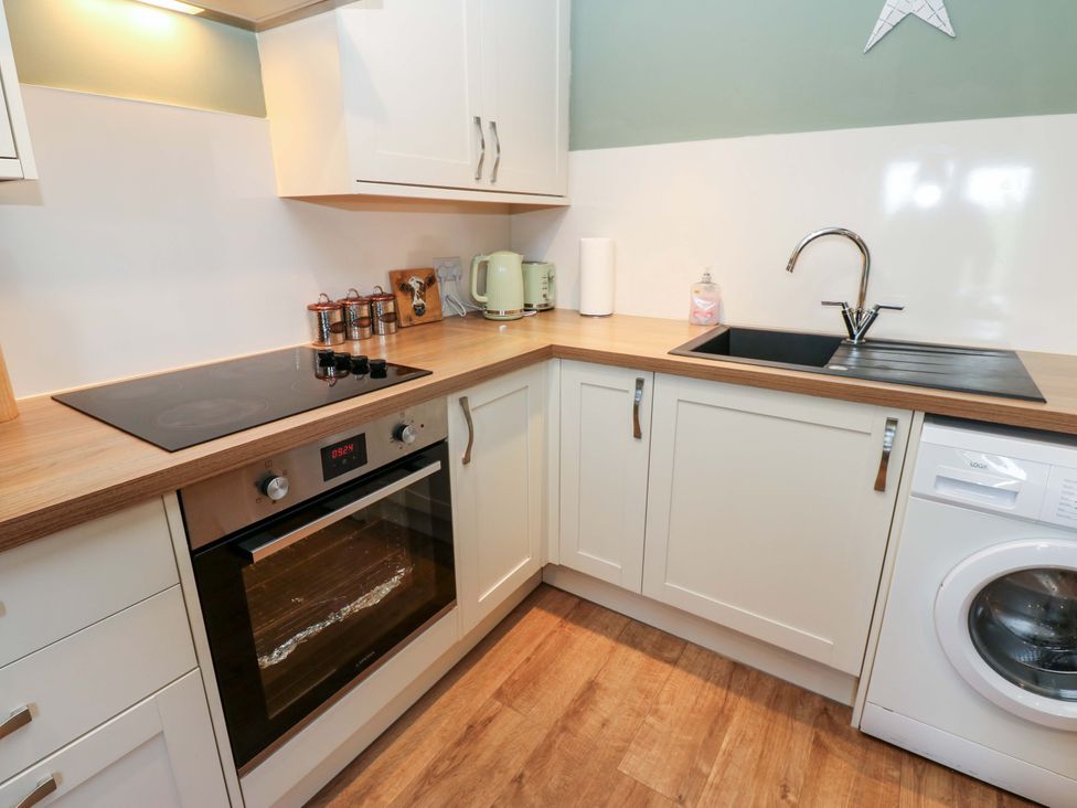 A kitchen with stove oven and sink at The Hayloft in Ellingstring near Masham